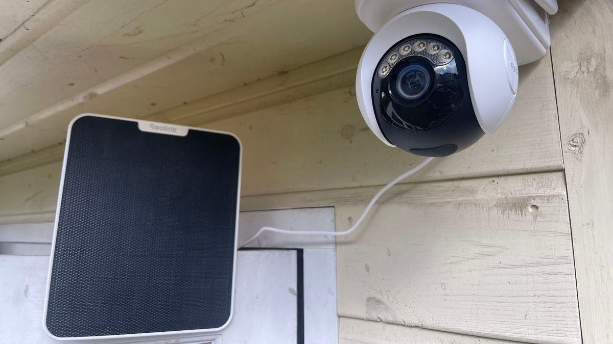Outdoor security camera with solar panel mounted on wall