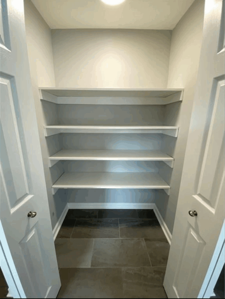 Empty pantry closet with clean white shelves and storage space