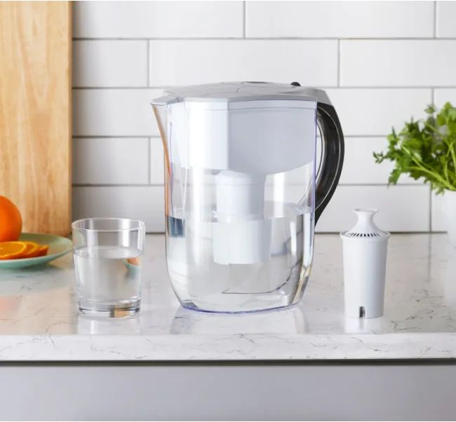 Water filter pitcher with glass of clean drinking water